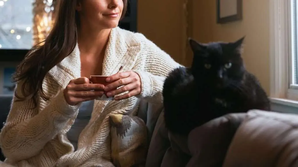 Woman and cat sitting on couch with peace of mind
